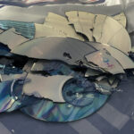 Snapped CDs in a plastic bag after manual destruction