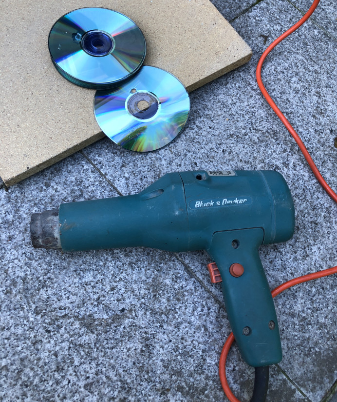 Deformed CD after heat gun application, showing melting and warping