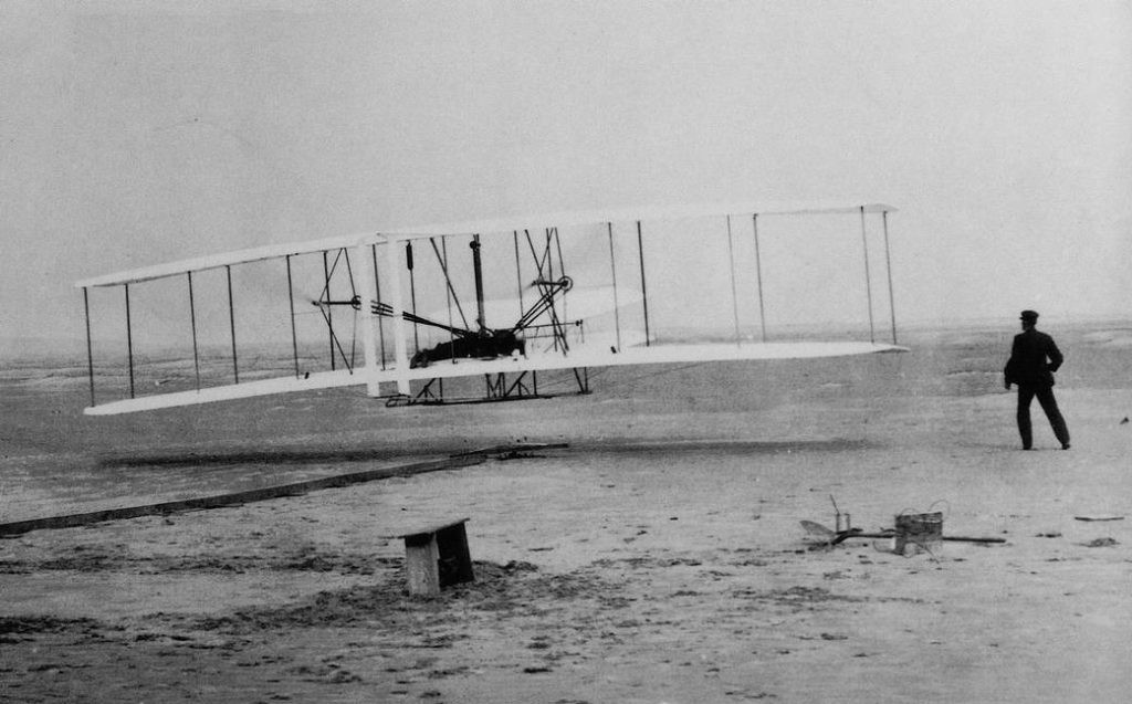 Orville Wright piloting the Wright Flyer during the historic first flight at Kitty Hawk, North Carolina on December 17, 1903.