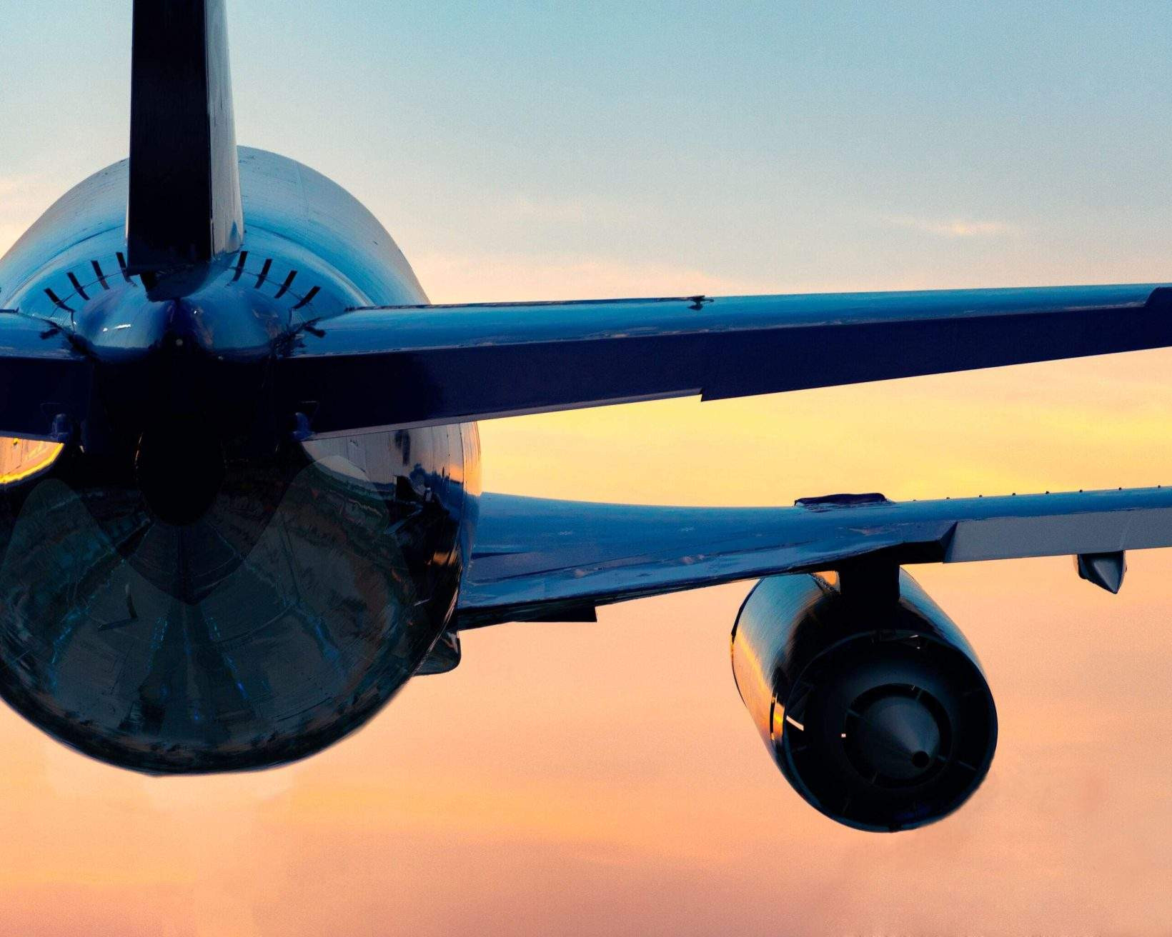 Airplane taking off into a vibrant sunset sky.