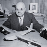 Henry J. Kaiser, shipbuilder, with a model of the H-4 Hercules, highlighting the ambitious scale of the project.