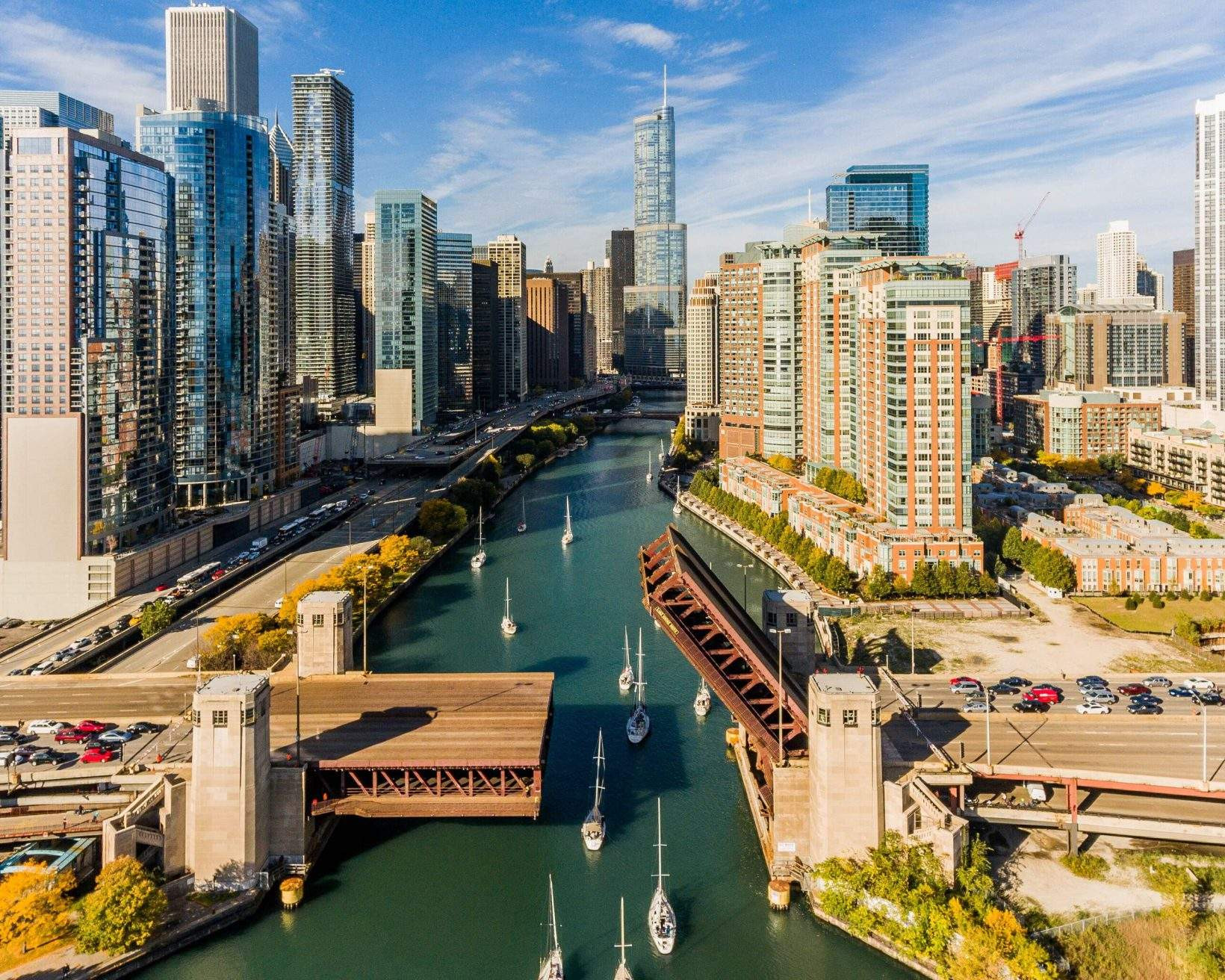 Aerial view of the Chicago River with boats and skyscrapers on both sides of the river.