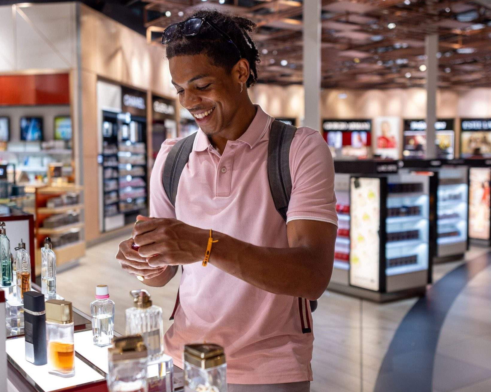 Man smelling aftershave in a duty-free shop at Toulouse airport.