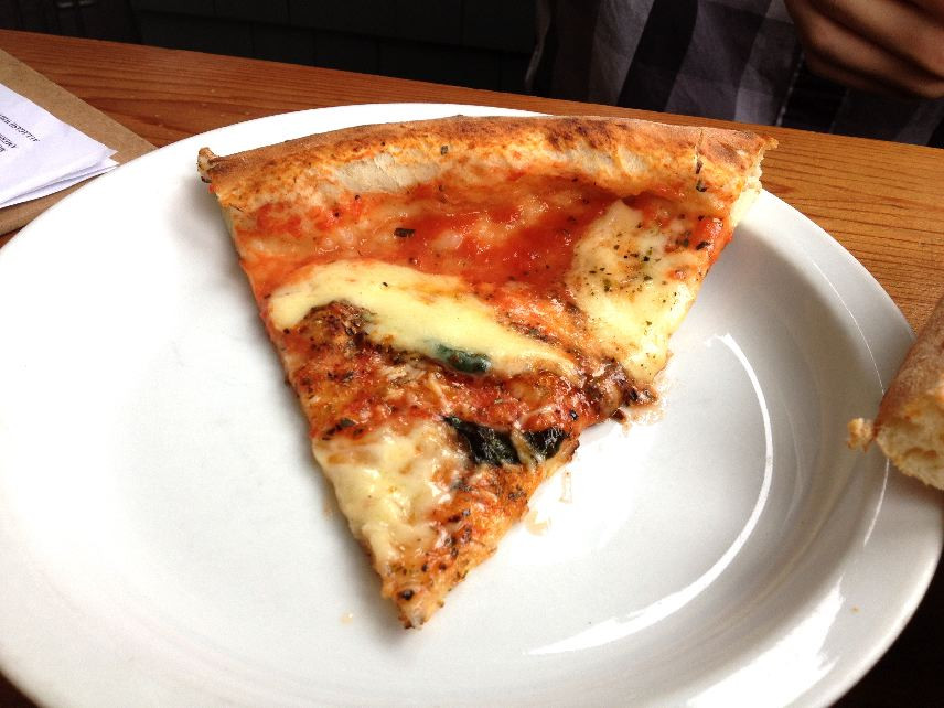 Close-up of a Margherita pizza slice at When Pigs Fly Pizzeria