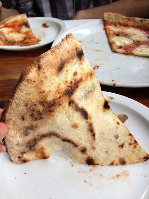 Underside of the pizza showing char and crust