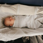 Infant sleeping in an airplane bassinet during international flight