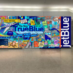 a wall with a picture of a plane and a jet blue sign