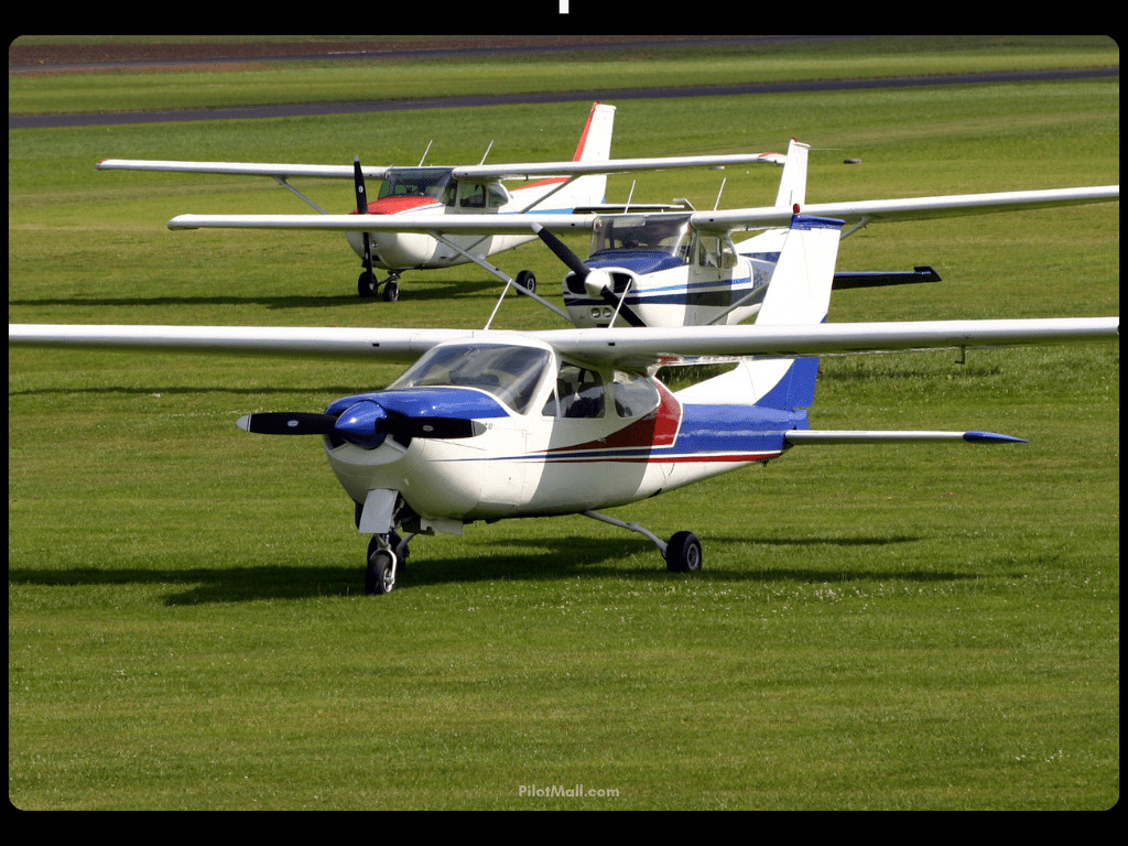 Three Cessna Airplanes Parked on Grass Field