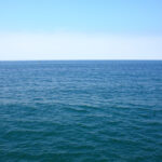 A serene ocean vista under a clear blue sky.