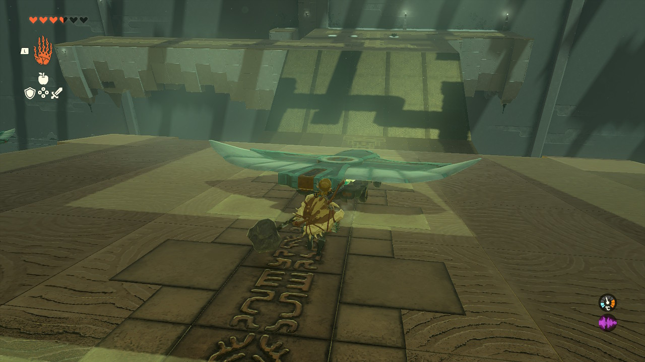 Link chasing after a wing-cart rolling down a slope in the Jirutagumac Shrine, utilizing a basic flying device for traversal in Zelda Tears of the Kingdom.