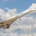 Concorde supersonic passenger plane in flight against a sky with light clouds