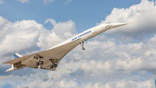Concorde supersonic passenger plane in flight against a sky with light clouds