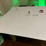 Cutting a big circle on foam board, the first step in crafting the base disks of the flying saucer.