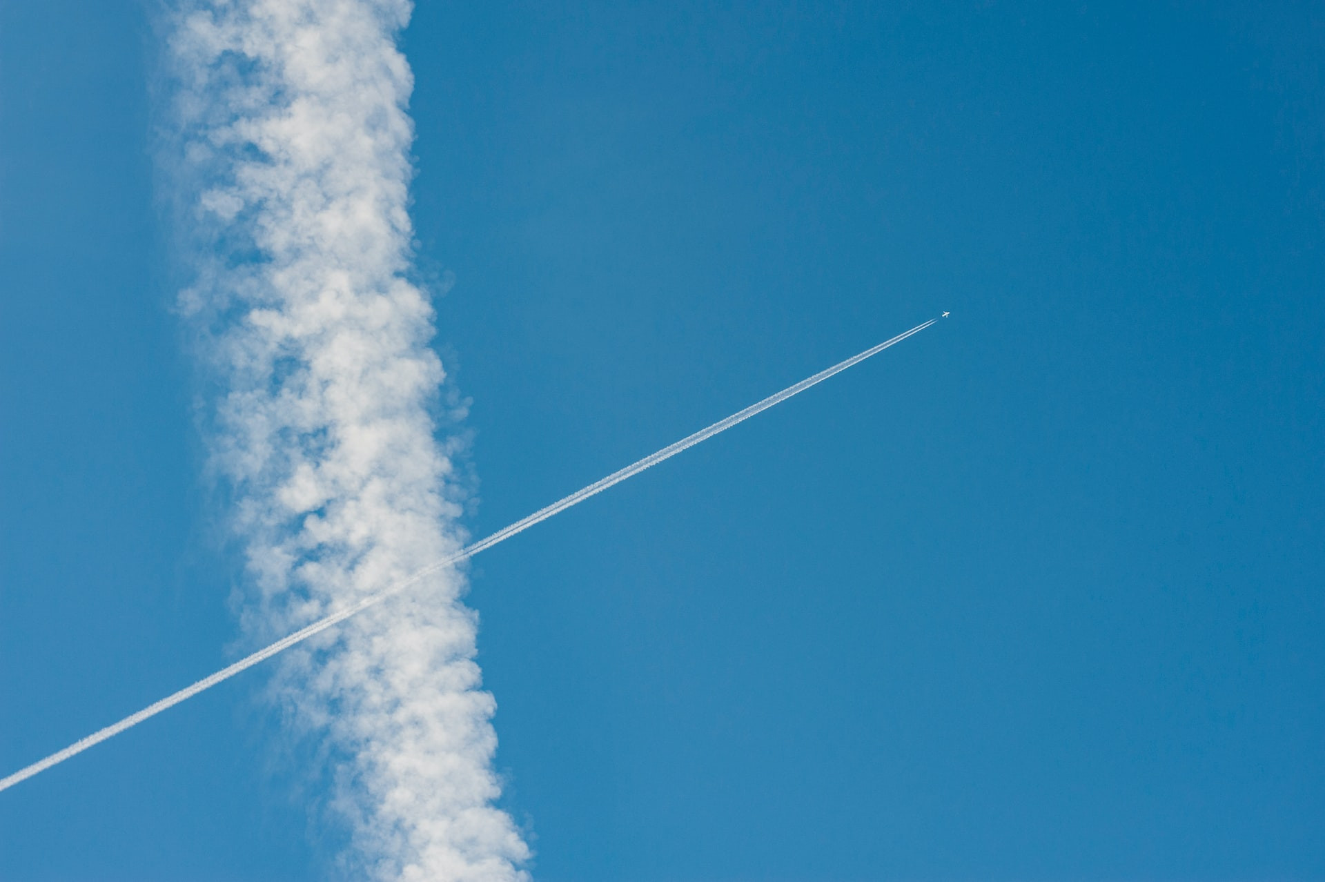 Aeroplane fly in which layer of atmosphere: Two planes flying in the sky with few clouds.