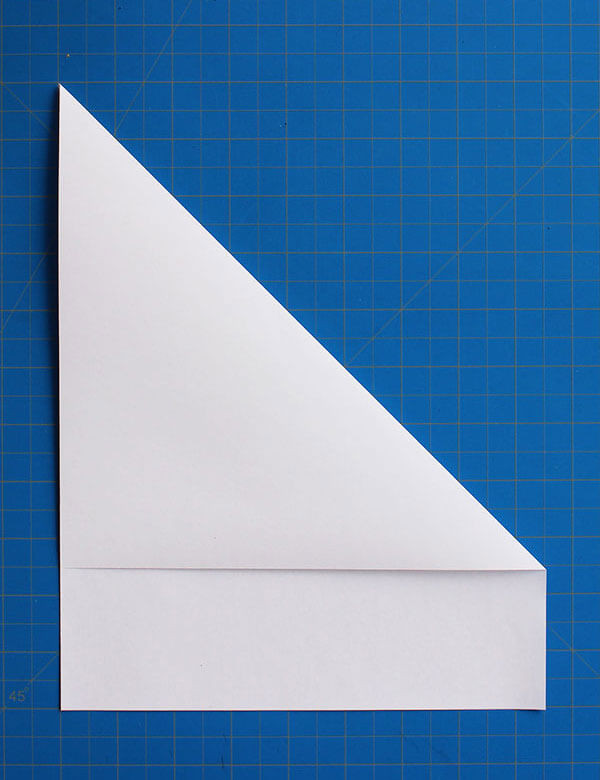 Step 1: Folding the top right corner diagonally to create a sharp crease for the initial wing guideline