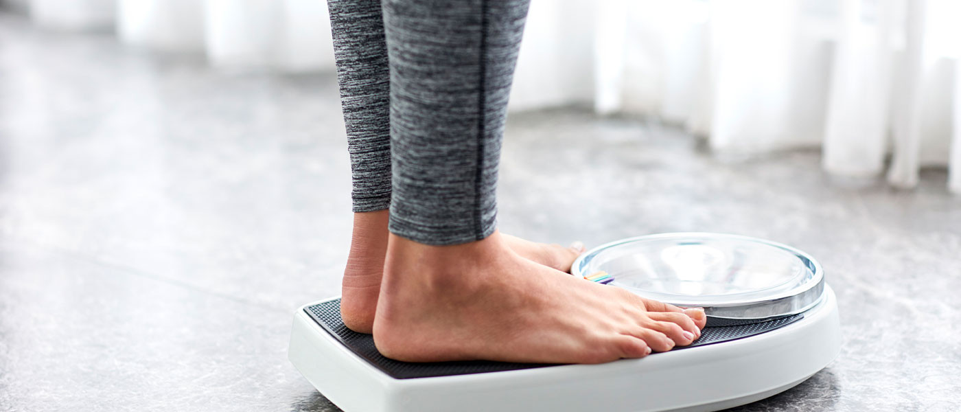 Woman in athletic wear smiling, symbolizing successful weight management through medication and lifestyle changes, courtesy of Genesis Lifestyle Medicine