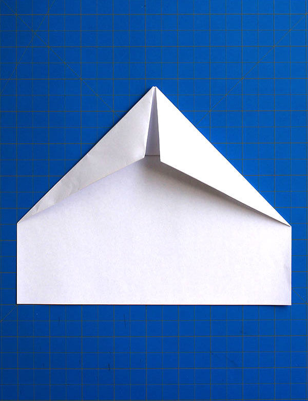 Step 8: Folding the top edges along diagonal lines to refine the wing shape for aerodynamic efficiency