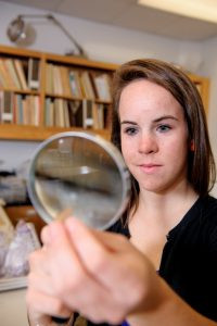 Smith examines a stone artifact, meticulously analyzing lithic tools as part of her archaeological research project in the field of history and international studies
