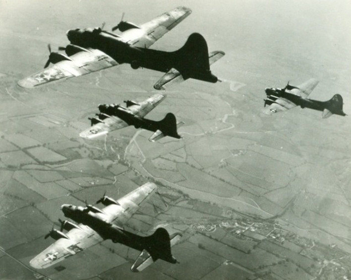 Four B-17 Flying Fortresses in tight formation, emphasizing their defensive firepower and teamwork during missions