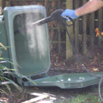 Cleaning a trash can with a spray bottle and cloth
