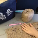 Woman crocheting on a plane, happy and relaxed