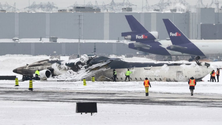 Wreckage of the Delta Airlines plane that crashed upon landing at Toronto Pearson Airport is seen on a tarmac as the investigation continues two days after the incident on February 19, 2025.
