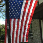 House-mounted US flag with black streamer for mourning