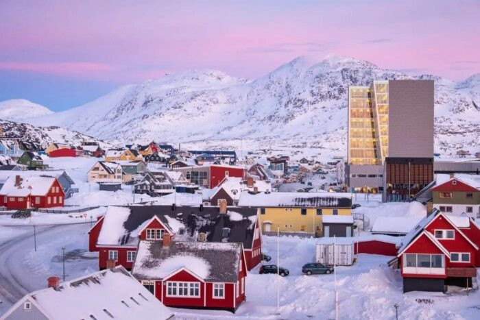 Aerial view of Nuuk, Greenland, showcasing the city's coastal location and colorful buildings against a backdrop of fjords and mountains