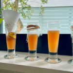 Four different DIY fruit fly traps are set up on a windowsill.