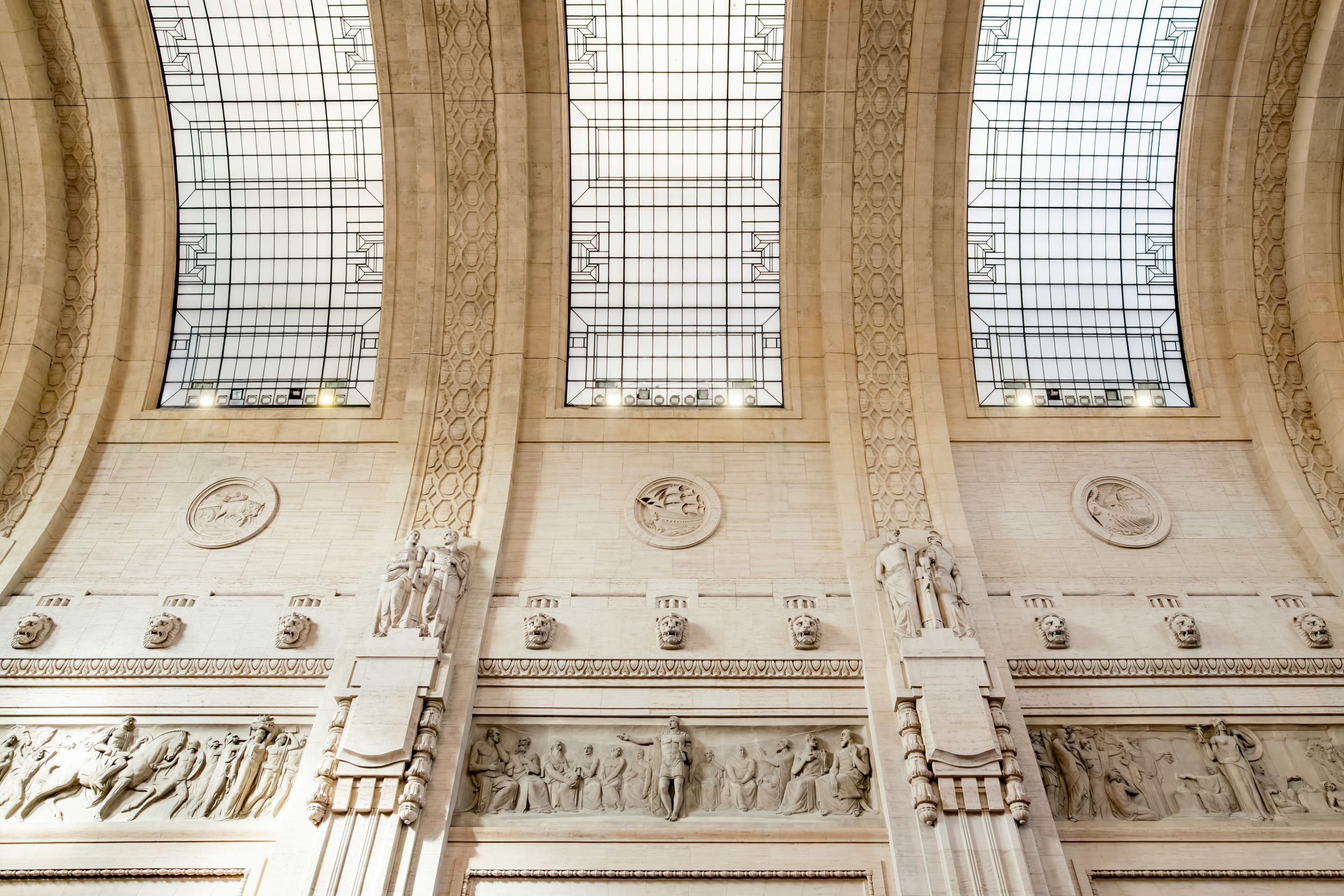 Ornate carvings and glass skylights in the stone ceiling of Milan