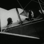 Helen Keller and Anne Sullivan in the cockpit of an airplane during the filming of "Deliverance," 1919, highlighting Keller's early aviation experience.