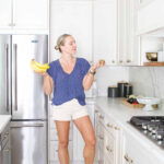 A woman holding fruit in the kitchen