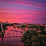 Aerial view of a Delta Airlines airplane flying over a city