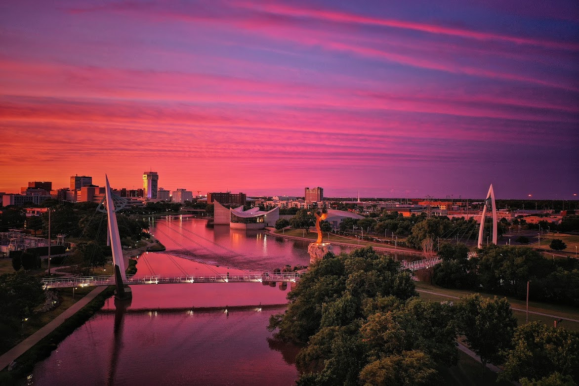 Aerial view of a Delta Airlines airplane flying over a city