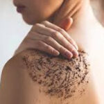A person gently scrubbing their arm with a mixture of coffee grounds and coconut oil, showcasing the use of coffee grounds as a natural exfoliating scrub for smoother, healthier skin.