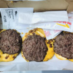 In-N-Out Flying Dutchman featuring two beef patties and melted cheese, displayed in a well-lit setting to highlight its simplicity and appeal to keto dieters