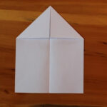 Paper airplane with first 2 steps completed.