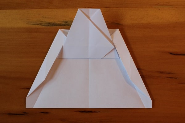 Both corners folded in — airplane almost done.
