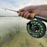 Fly fishing gear for largemouth bass, including a fly rod, reel, and fly box