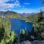 Man standing near mountains and lake