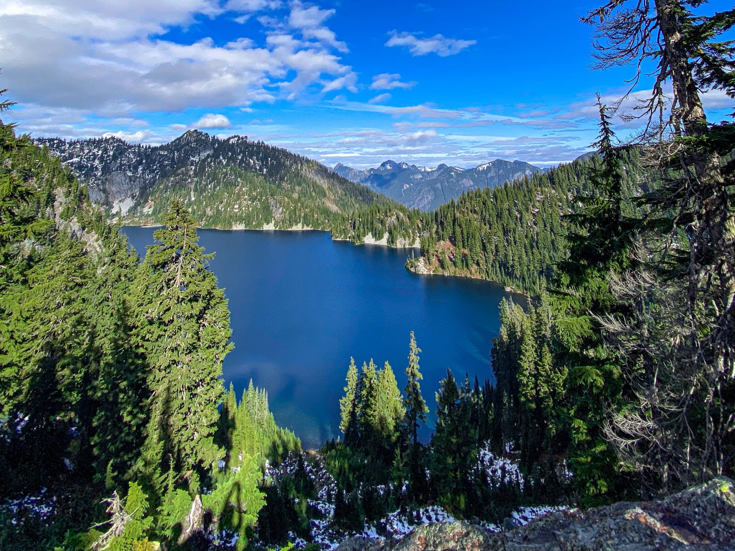 Man standing near mountains and lake