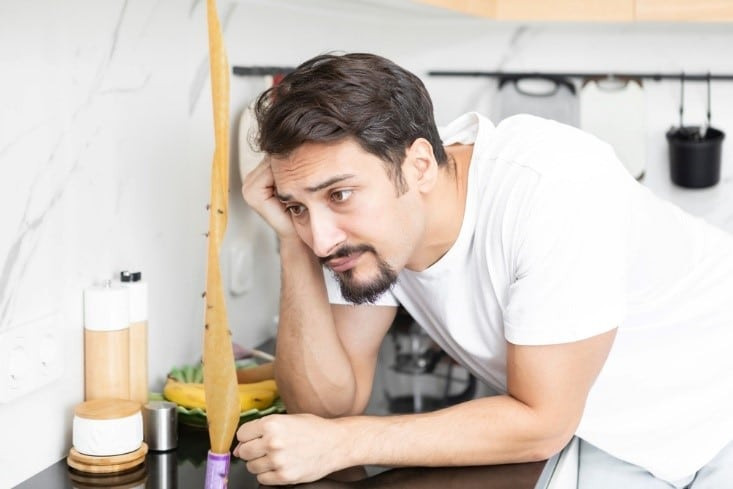A man dealing with a house fly infestation in his kitchen.