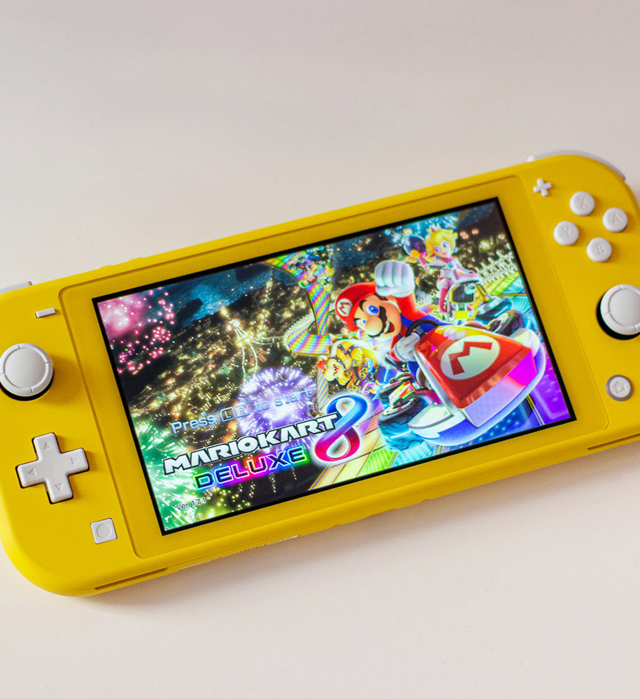 A yellow Nintendo Switch Lite with the Mario Kart 8 Deluxe homescreen on it