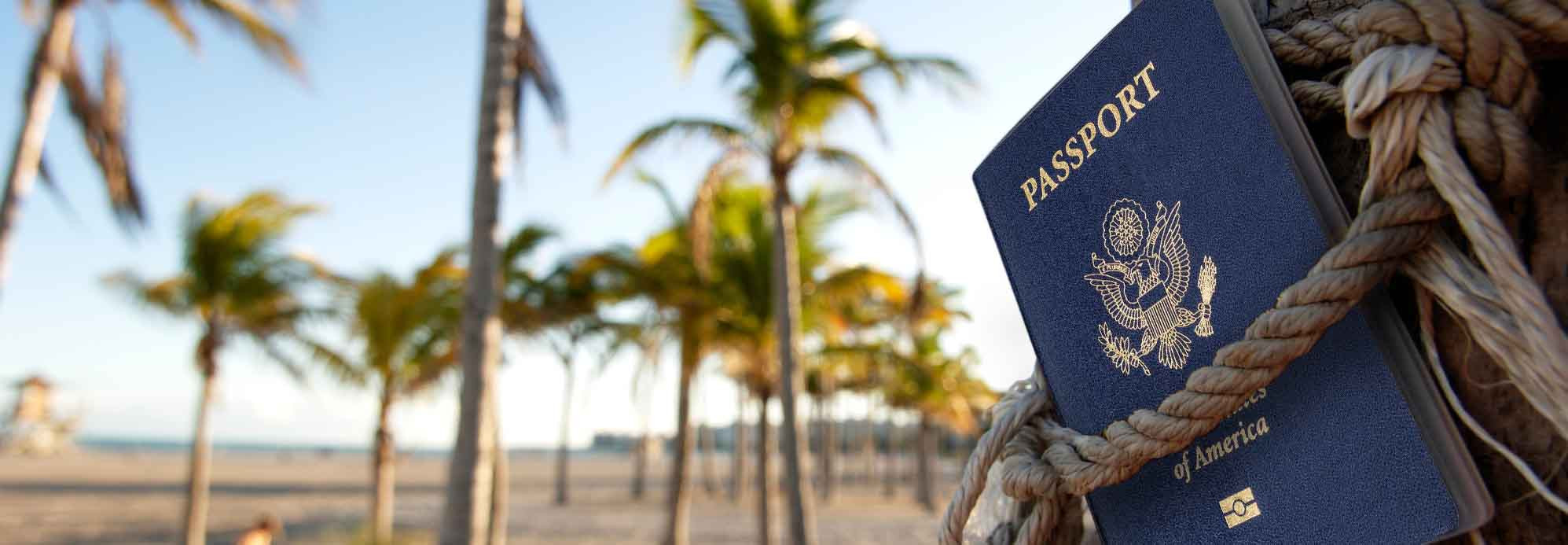 us passport tied to palm tree on beach