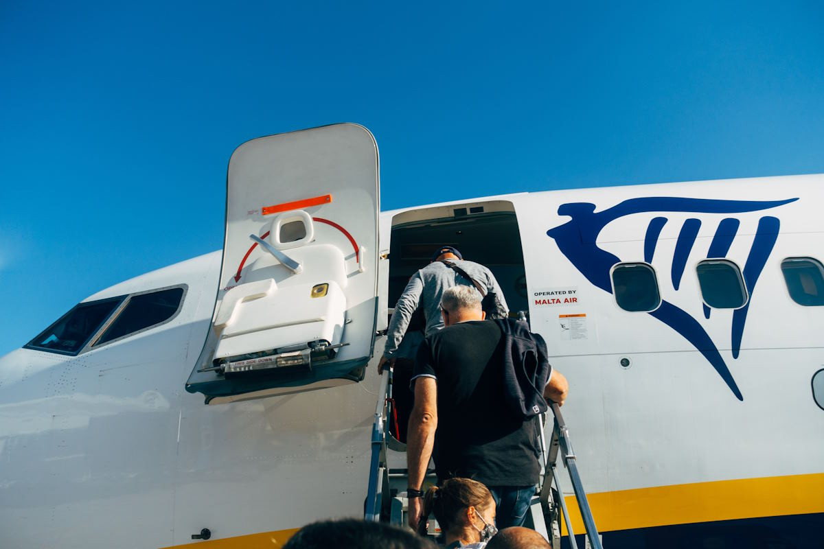 People walking up the stairs to board a plane