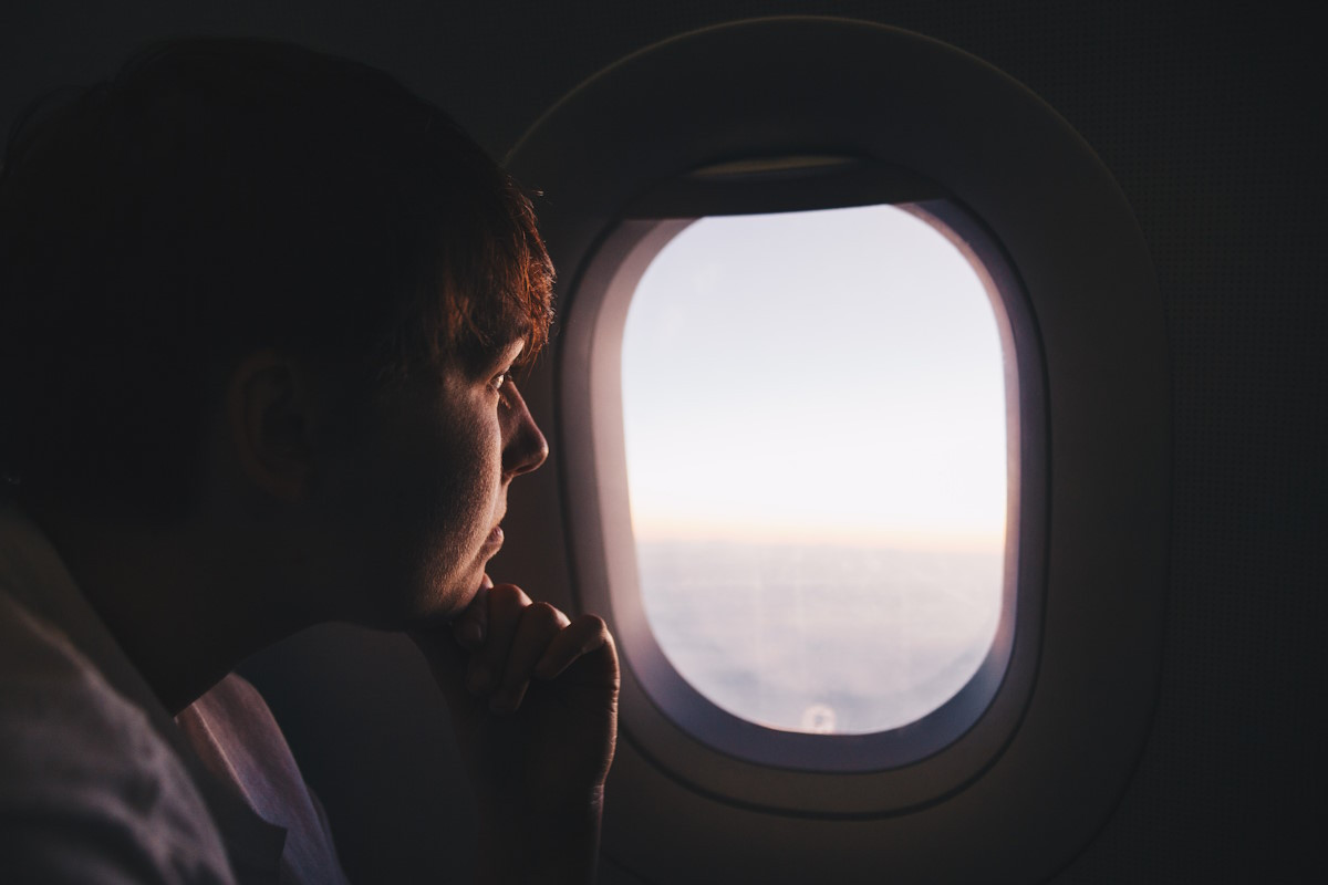 Man looking out of the window on a plane