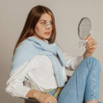 Rhinoplasty patient looking at herself in the mirror asking if she could fly during her recovery.