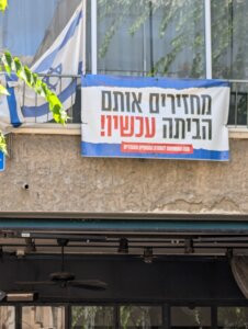 Near the light rail station Yehudit in Tel Aviv, a sign says ‘Bring Them Home Now.’