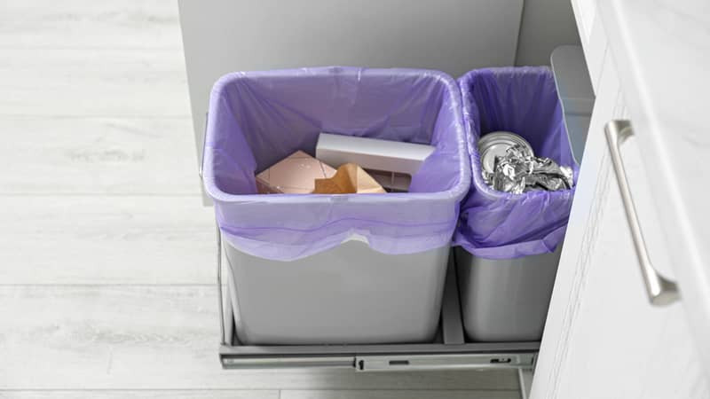 A brimming rubbish bin overflowing with household waste