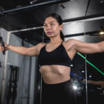 Person standing in a gym setting up for a cable chest flye